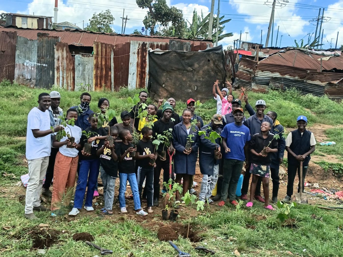 Youth and children planting trees together in Korogocho